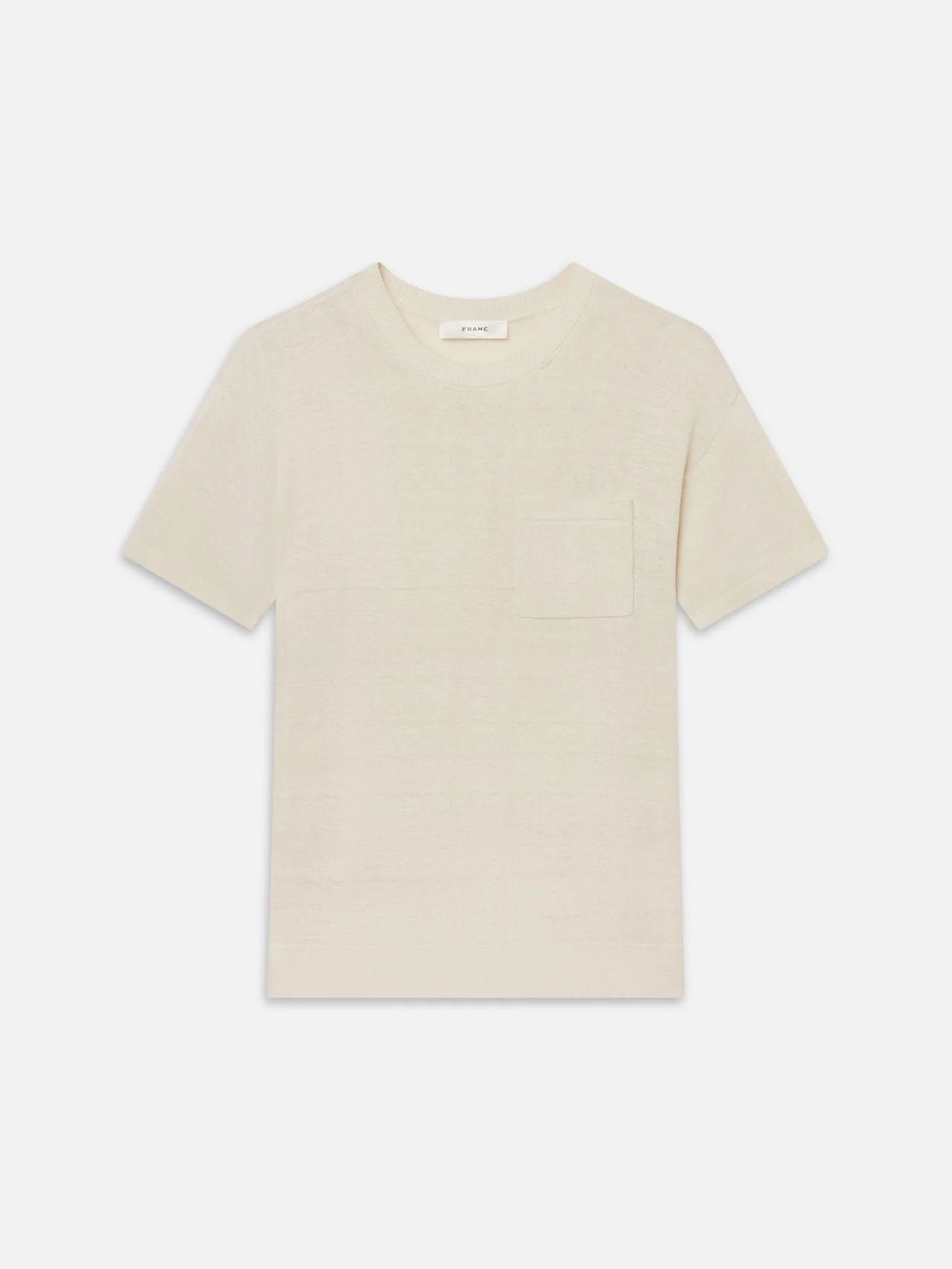 The Knit Plus One Tee by FRAME is a relaxed-fit, light beige short-sleeve t-shirt with a crew neckline and chest pocket, shown on a white background.