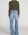 FRAME The Cashmere Airy Cardi sweater in ivory with light blue wide-leg jeans on a minimal background.