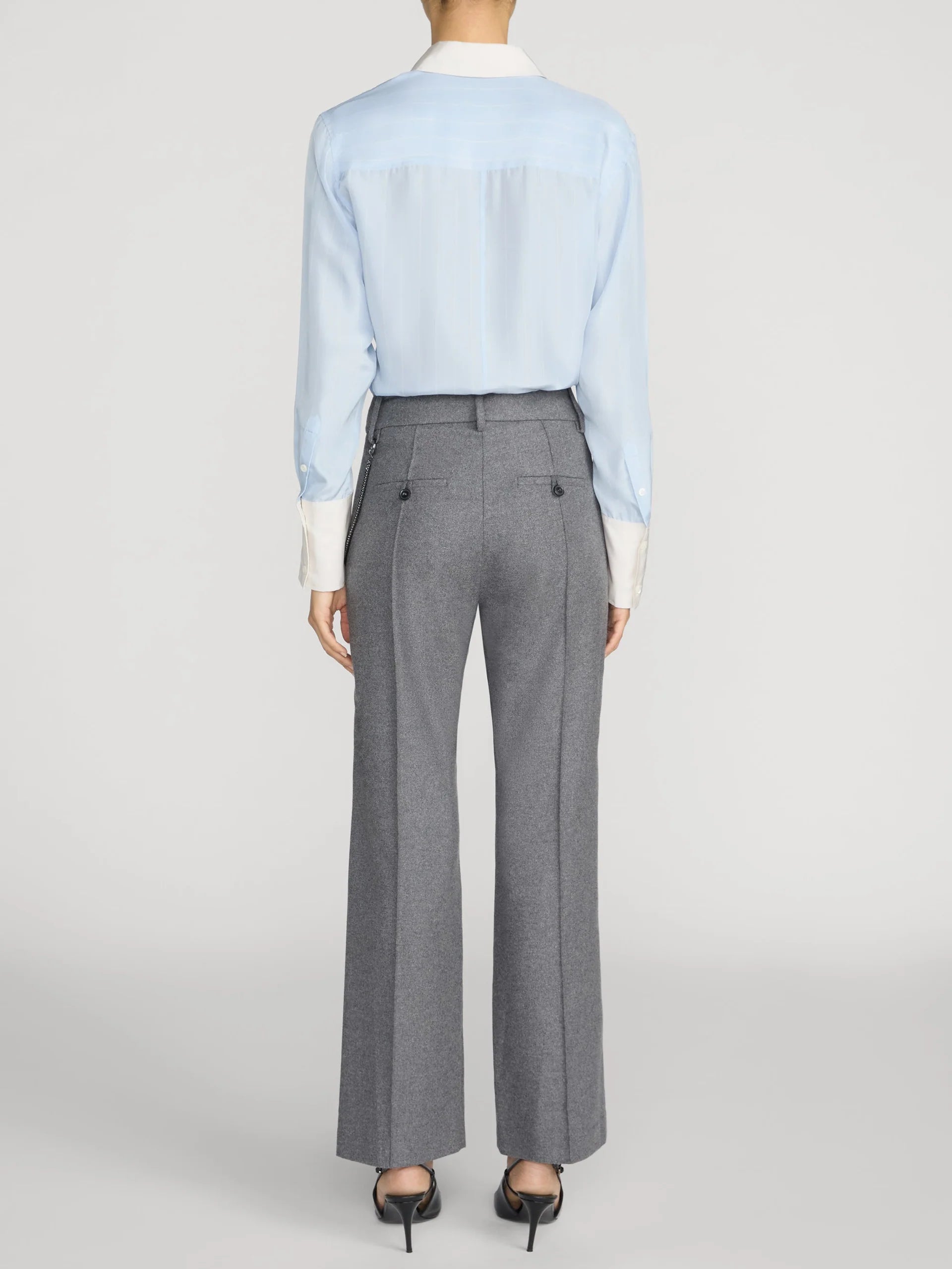 Striped silk shirt by FRAME styled with gray dress pants and black heels, back view.
