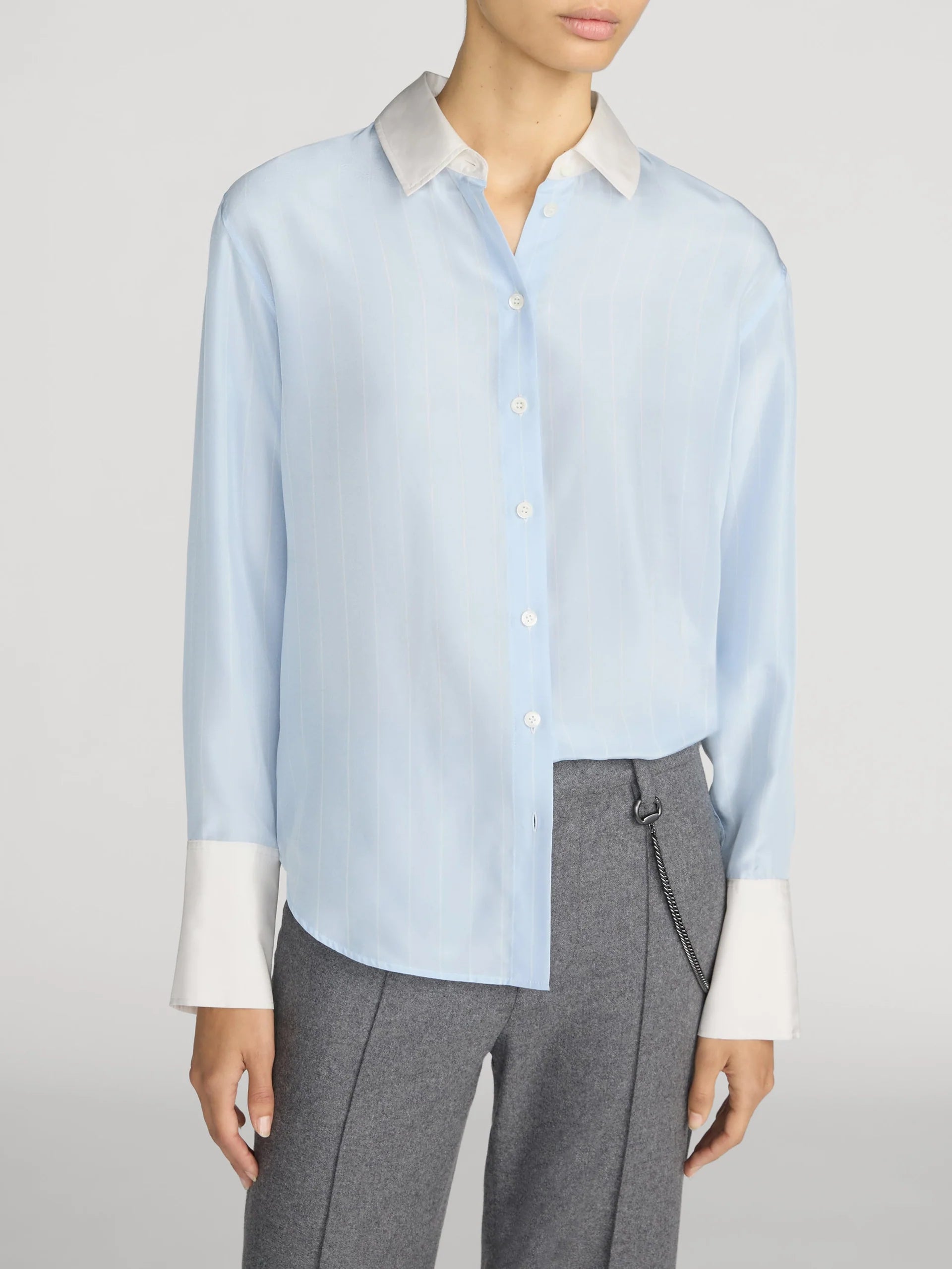The Silk Standard Shirt by FRAME with contrast collar and cuffs, styled with gray pants in a modern setting.