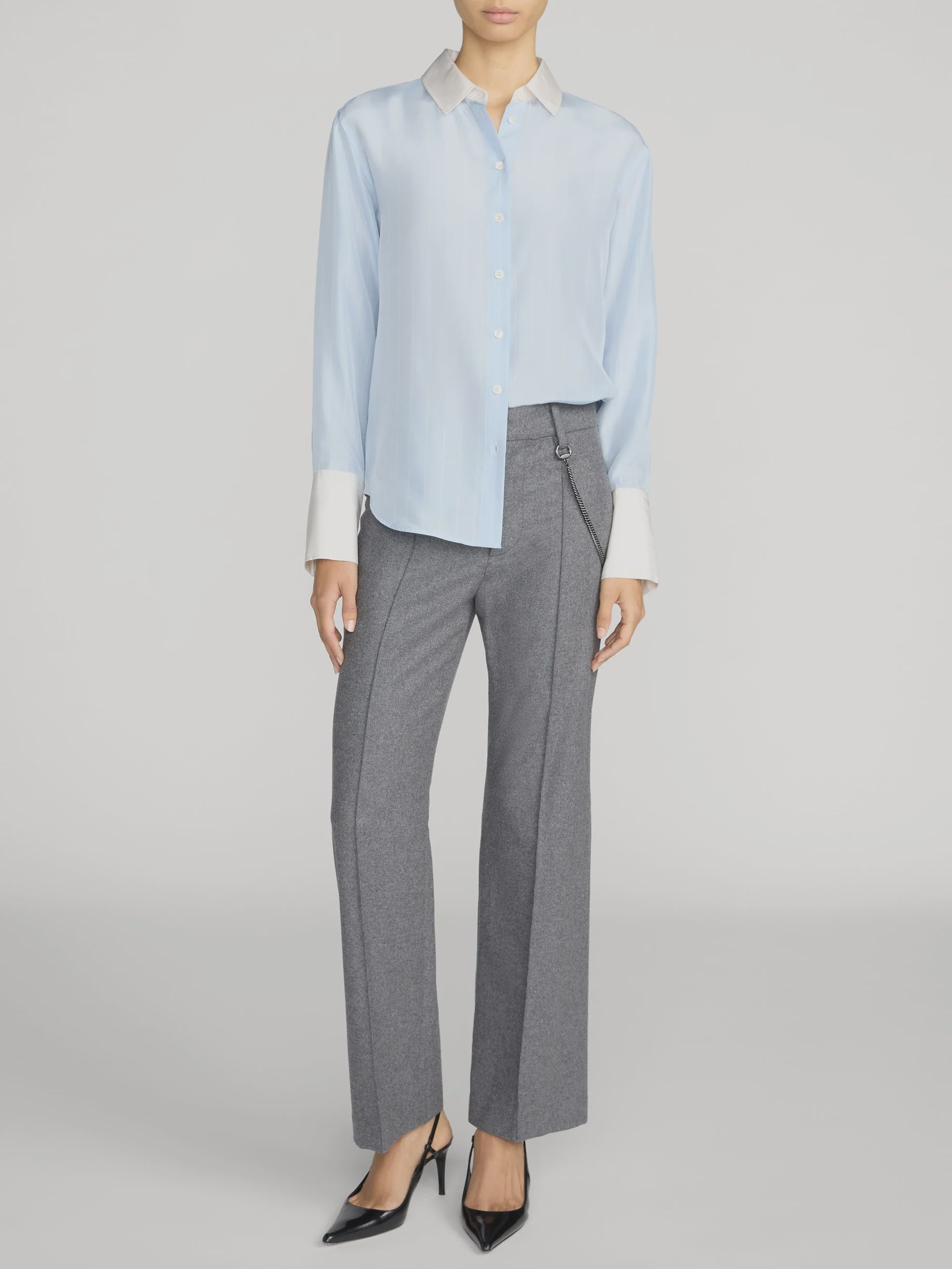 The Silk Standard Shirt by FRAME in gray, styled with zip trousers and black heels in a modern setting.
