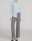 The Silk Standard Shirt by FRAME in gray, styled with zip trousers and black heels in a modern setting.