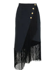The Le Superbe Utility Fringe Skirt is a black midi skirt featuring gold buttons and long black fringe at the hem for a modern layered effect.