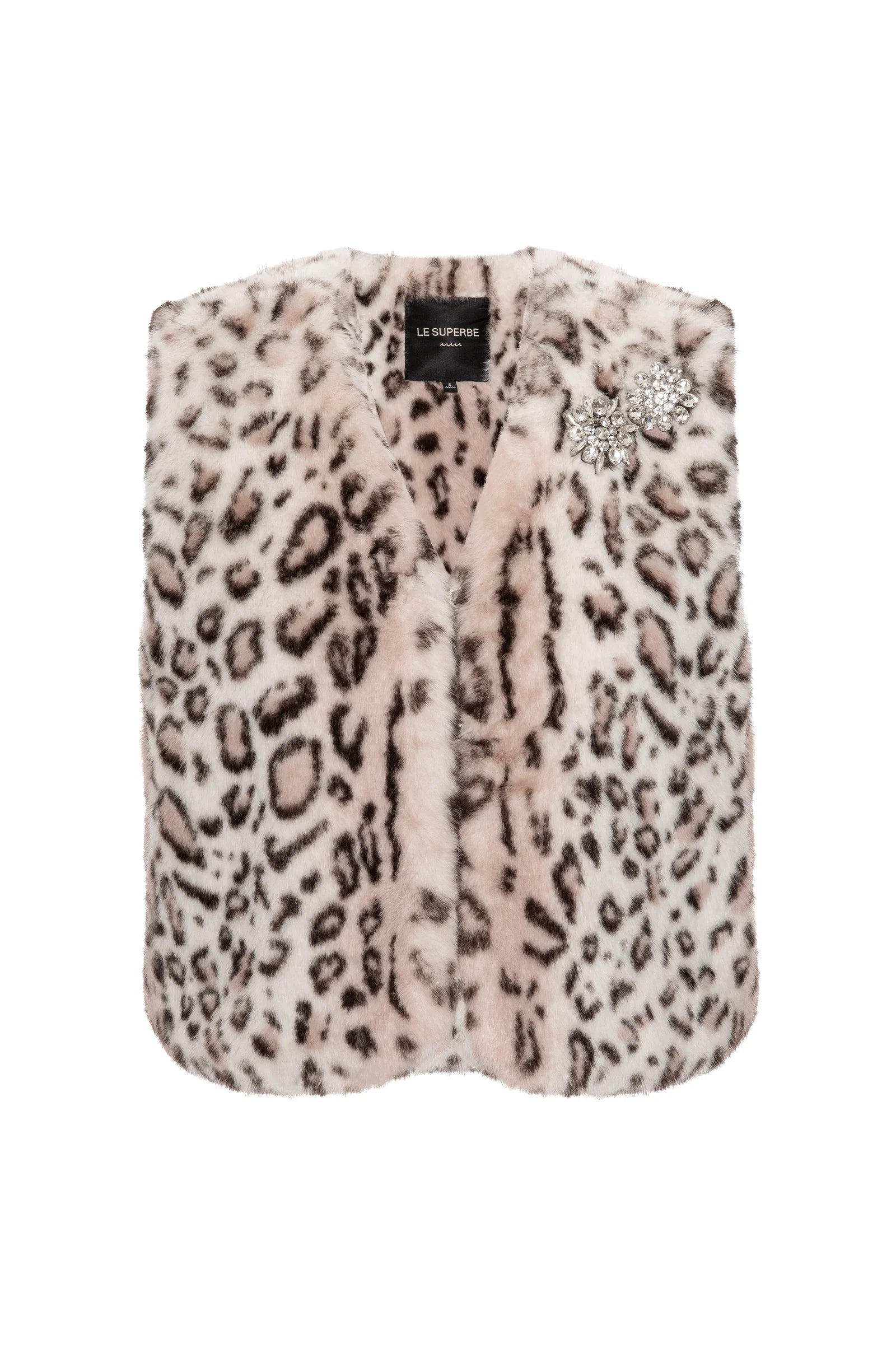 The Treasure Vest by Le Superbe is a sleeveless cropped faux fur vest in light pink and dark brown leopard print, adorned with a sparkling rhinestone brooch near the collar.