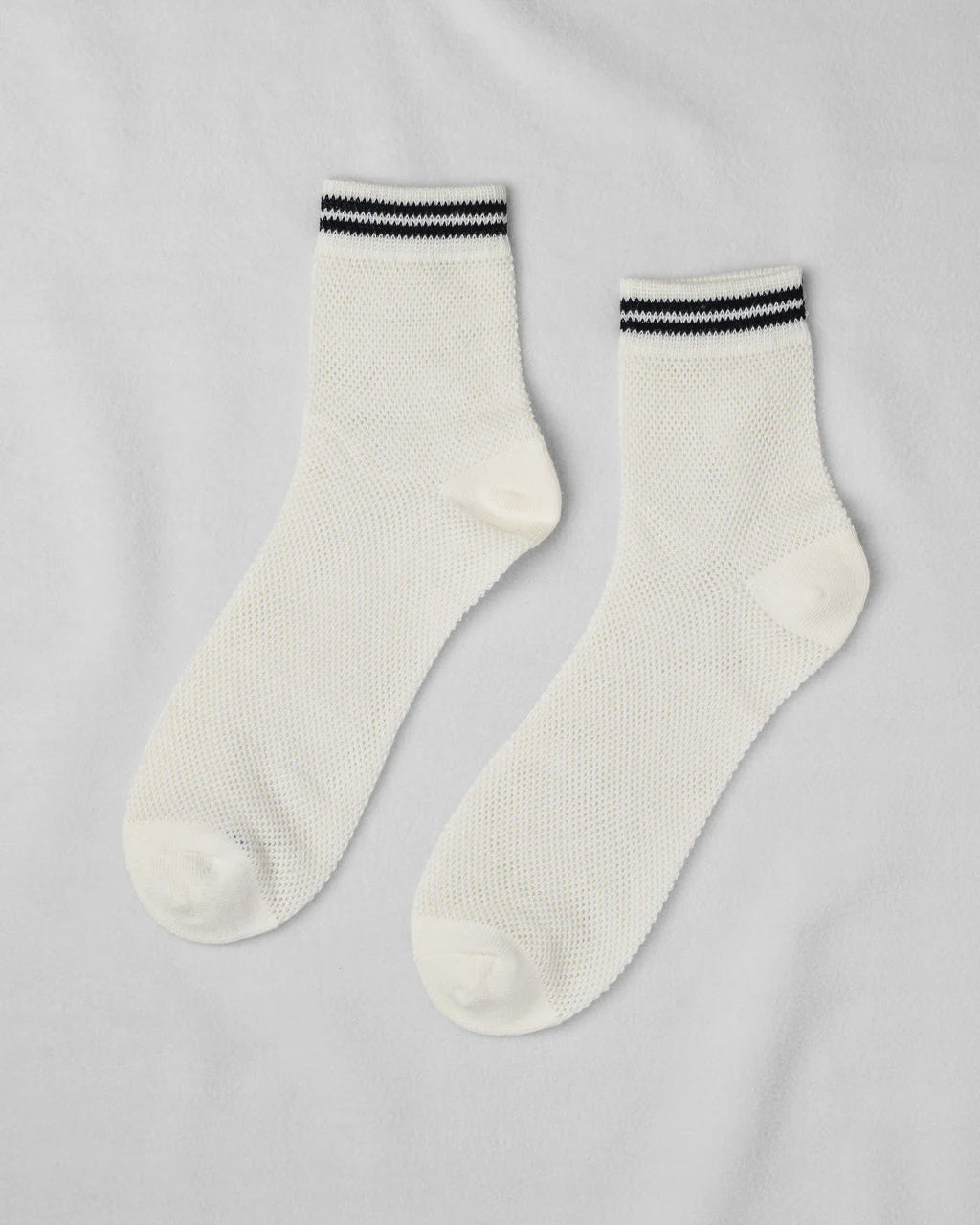 Unified Mesh Sneaker Socks in white feature black and white striped cuffs. Crafted from breathable cotton, these short crew ankle socks are displayed flat on a light gray background.