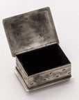 The Small Stamped Box w/ Turquoise by J Alexander Rustic Silver is a rectangular silver box with wavy engravings, a hinged lid, and an empty dark interior, displayed on a light surface.