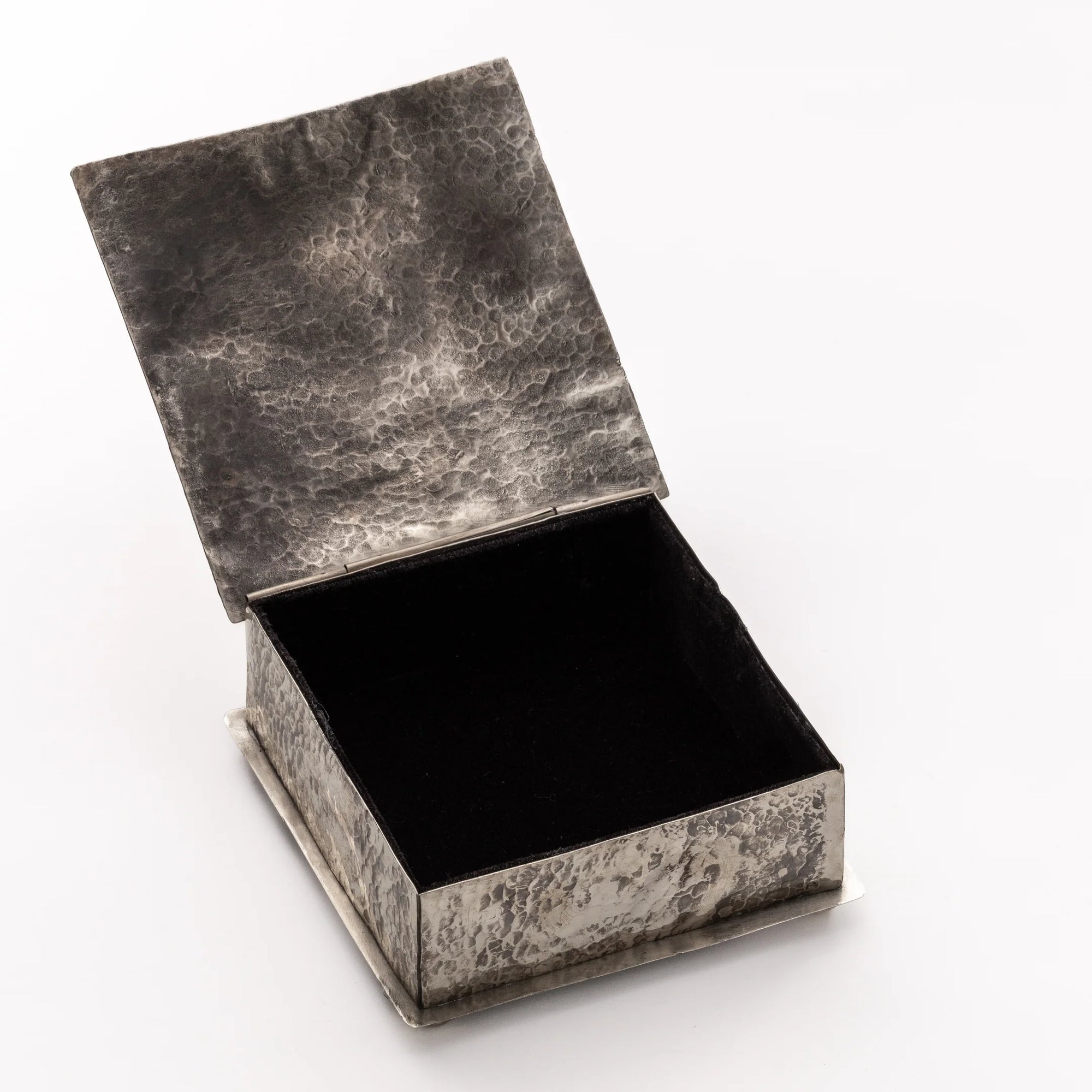 The SQ Silver Box w/ Dimples Cross by J Alexander Rustic Silver is a small, square, rustic silver box featuring a hammered surface with an open lid that shows its black interior, displayed on a plain white background.