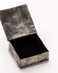 The SQ Silver Box w/ Dimples Cross by J Alexander Rustic Silver is a small, square, rustic silver box featuring a hammered surface with an open lid that shows its black interior, displayed on a plain white background.