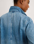 A person with short hair is seen from behind wearing the Alex Mill Britt Work Jacket, a garment-dyed denim piece with the collar turned up, against a plain light-colored background.