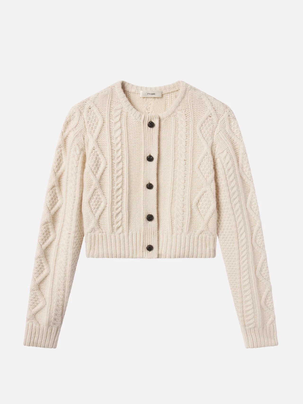 The Cable Knit Cardi by FRAME is a cream-colored, long-sleeve cashmere cardigan with a round neck, ribbed cuffs and hem, and five dark leather buttons down the front.