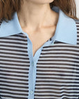 Someone wears the FRAME Collared Cardi, a sheer brown and white striped button-front cardigan with a light blue collar and buttons. The image is cropped to show only the neck, shoulders, and upper chest.