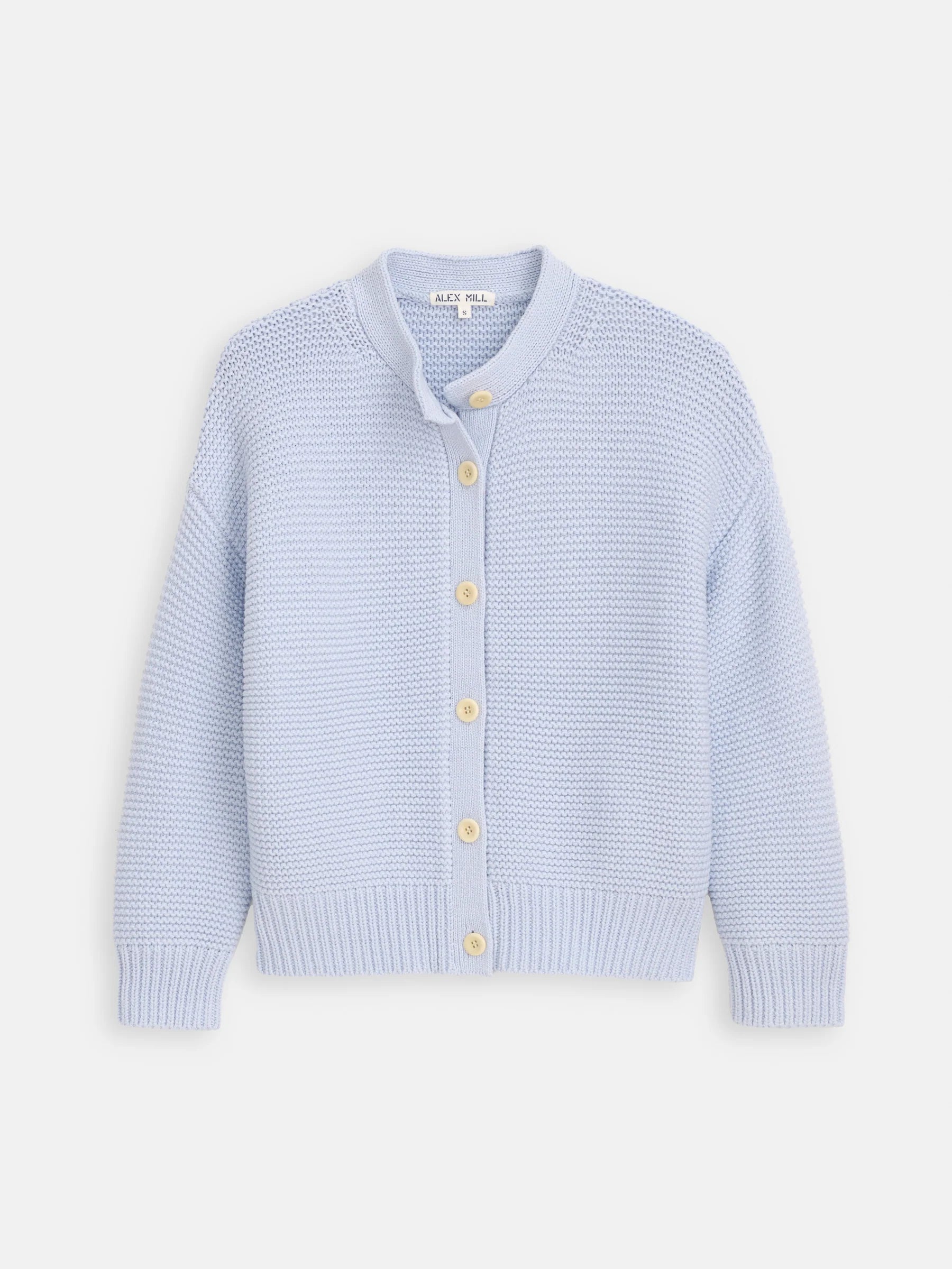 The Nico Chunky Cardigan by Alex Mill is a light blue cotton knit with a round neckline, long sleeves, cream Corozo buttons, and ribbed cuffs and hem, shown against a white background.