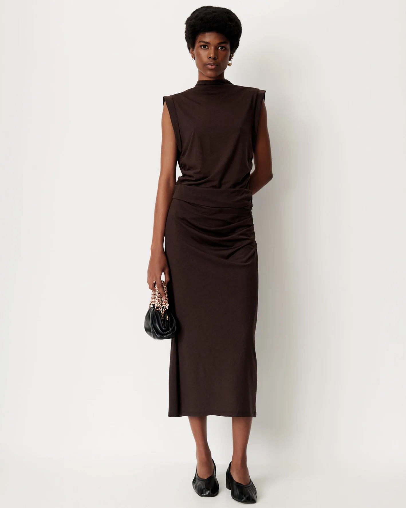 Brown DOLISH long skirt by Sessun styled with a black bag, shown against a plain white background.