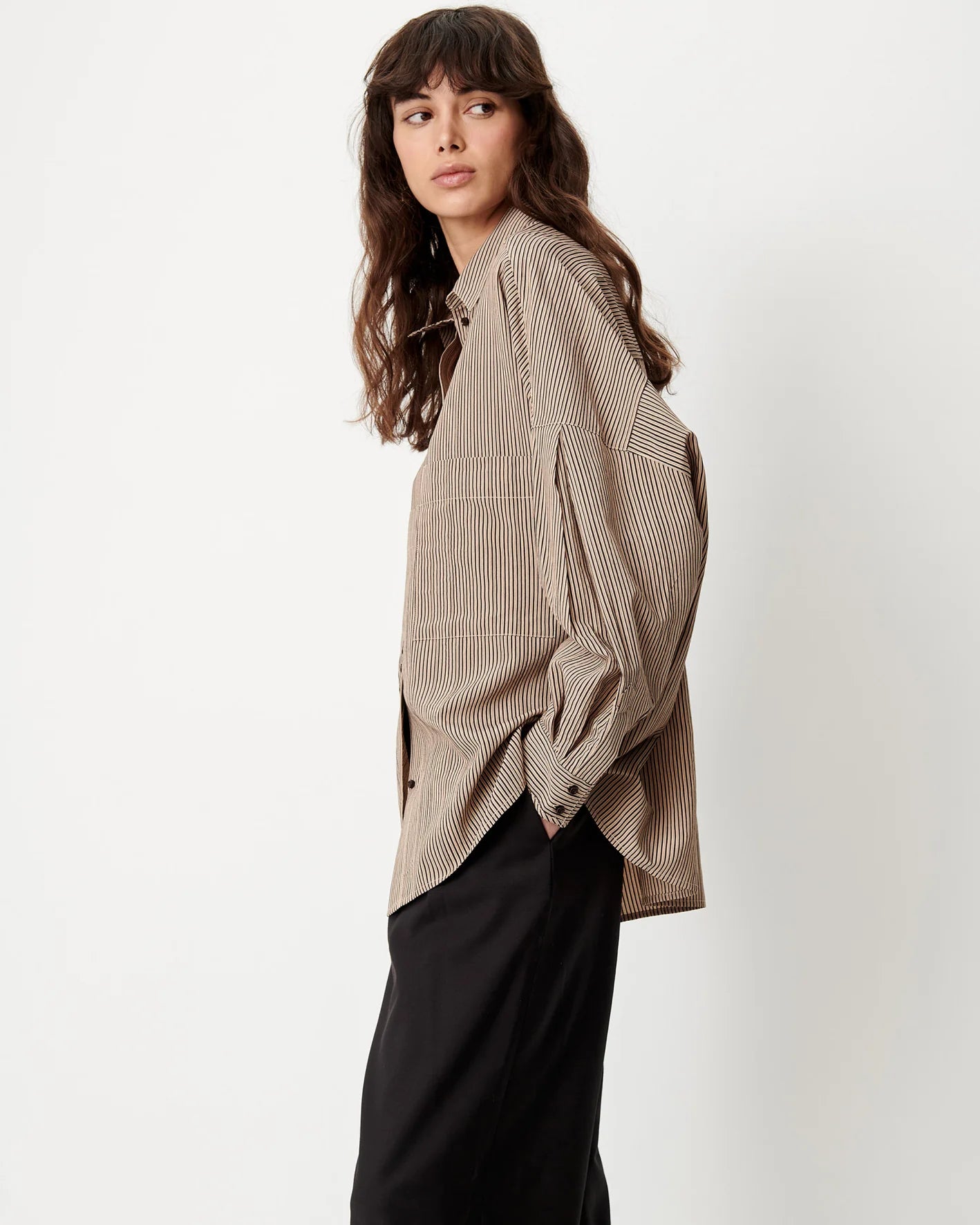 Sessun FONTANIA shirt with front pockets and black pants, model facing left against white backdrop.