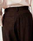 Sessun Orozco Large Pant in brown pinstripe with pleats, shown from the back, styled with a pale pink shirt.
