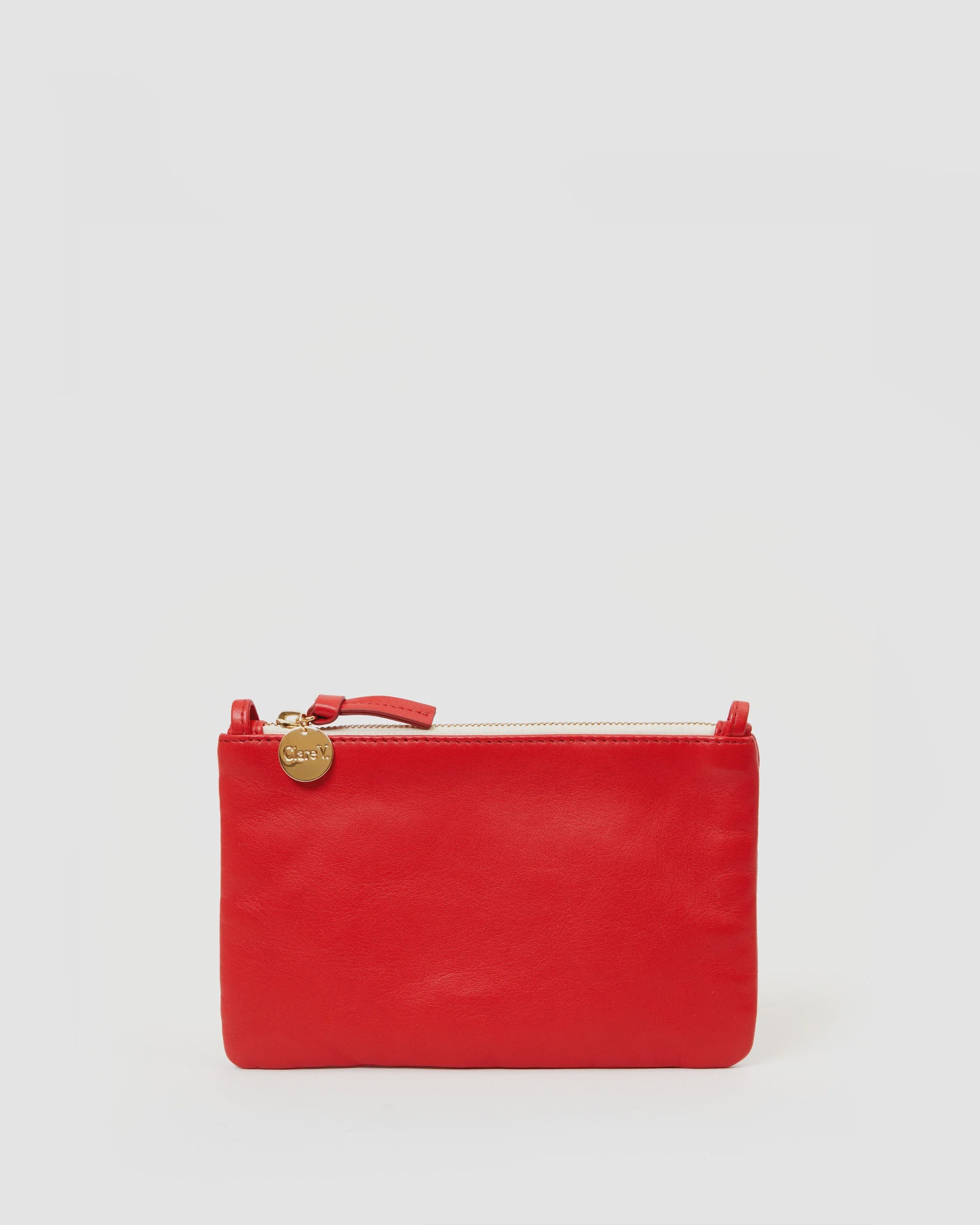 A Clare Vivier red Wallet Clutch w/Tabs made from Italian nappa leather, with a gold charm on the zipper pull, displayed on a plain white background.