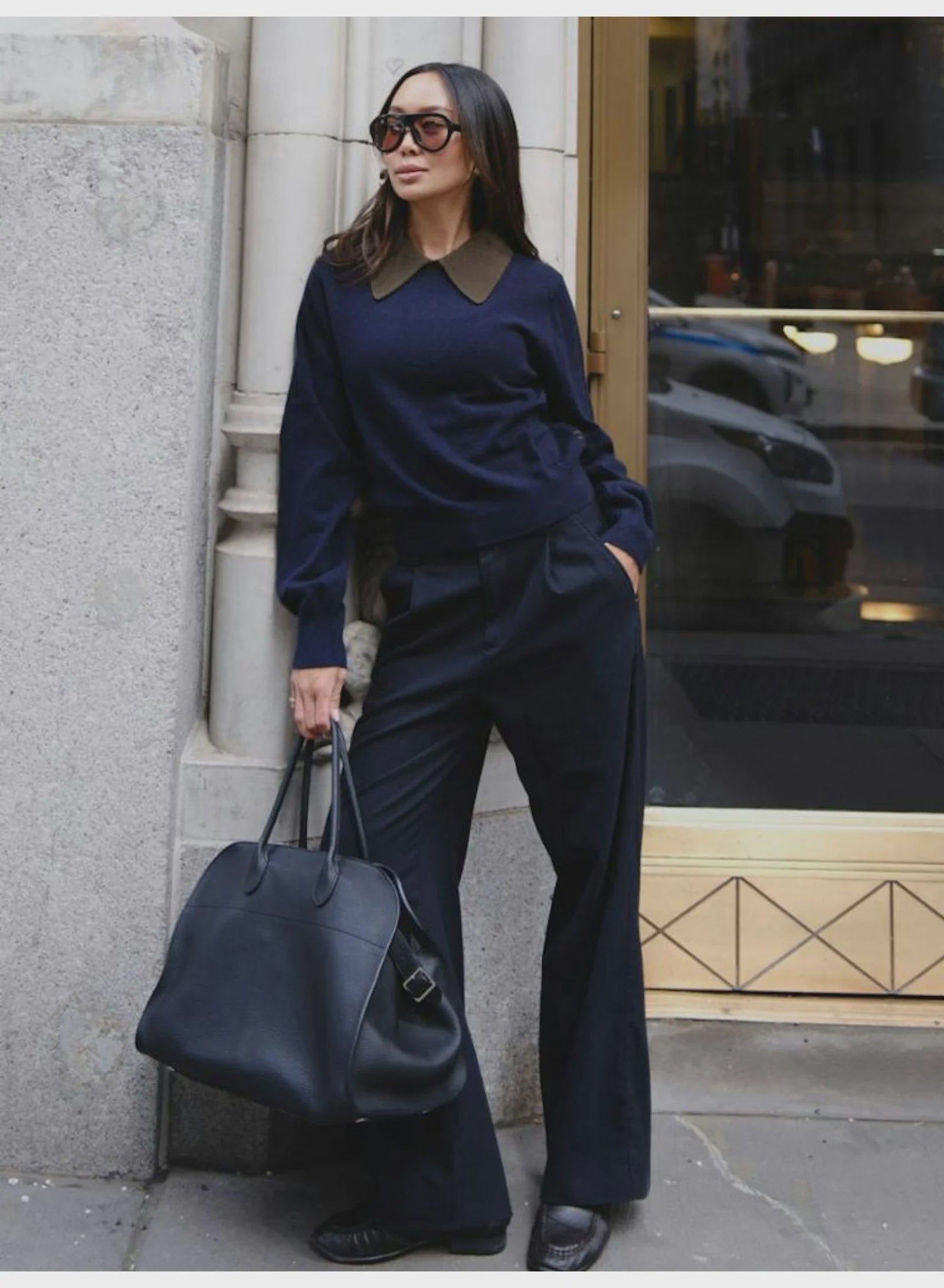 White + Warren cashmere contrast collar sweater on woman in sunglasses, relaxed city street setting near stone wall.