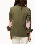 Green blazer with pink heart elbow patches by Kerri Rosenthal, Workday Love Brigade, shown from the back.