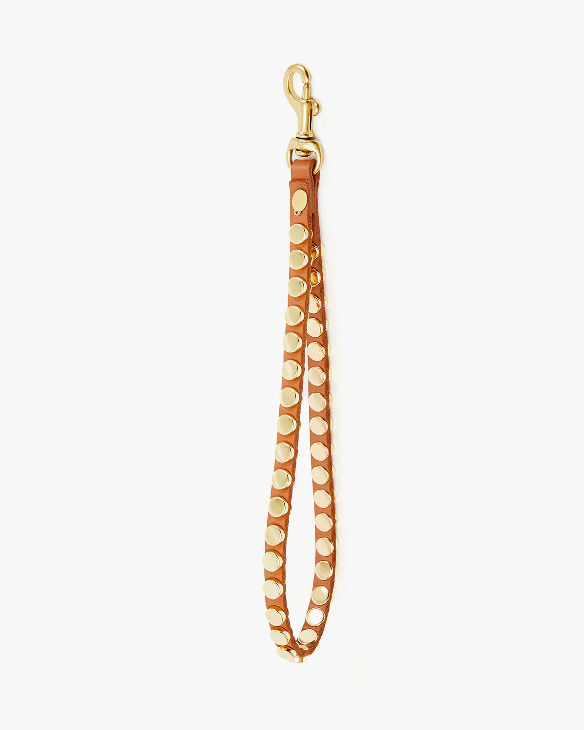 The Clare Vivier Wristlet is a brown Italian leather accessory featuring gold metal studs and clasp, perfect as a keychain or accent piece. Shown laid flat on a white background.