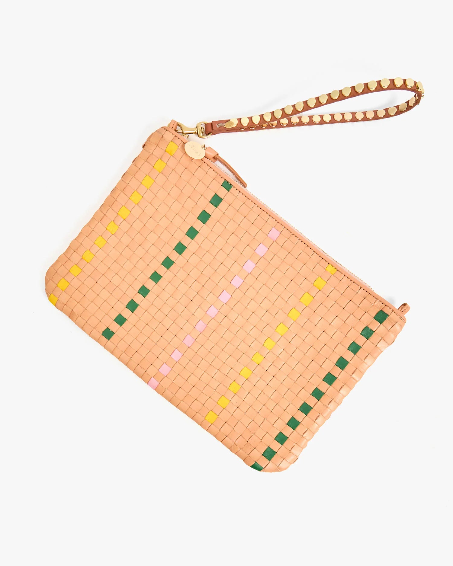 The Clare Vivier Wristlet is a peach-colored woven clutch with a wrist strap, decorated with vertical green, yellow, and pink accents. It features a zipper closure and a gold circular charm on the strap.