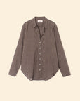 The Beau Shirt by Xirena is a menswear-inspired, long-sleeve button-up in black and white small checks, made from crisp cotton poplin with a collar and curved hem, shown against a plain beige background.