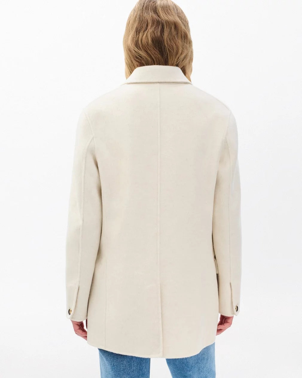 A person with long, light brown hair is shown from the back, wearing the Rag & Bone zoe wool blazer in cream and blue jeans against a plain white background.