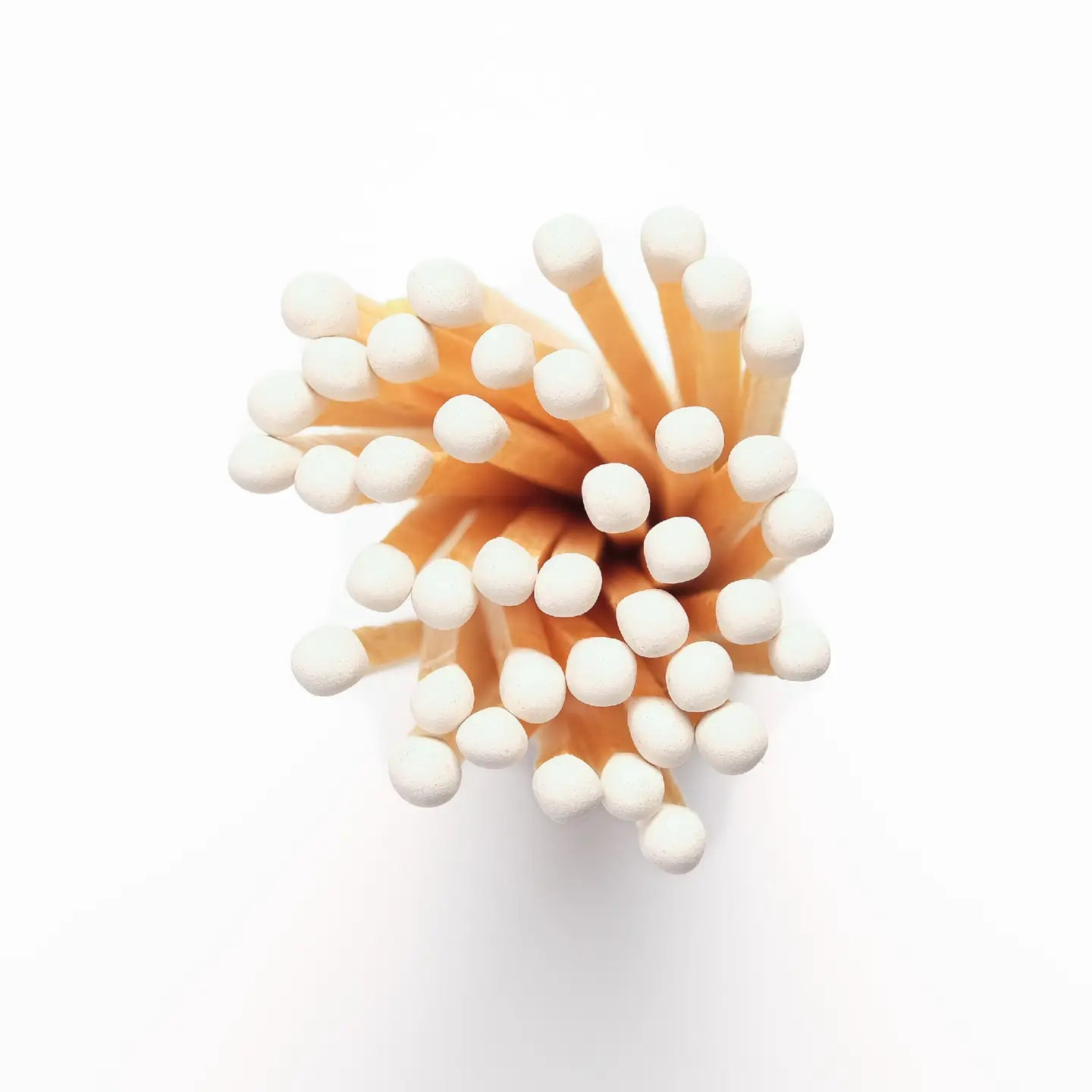 A cluster of Faire Fireplaces Apothecary Matches with white tips is arranged closely together, viewed from above against a white background.