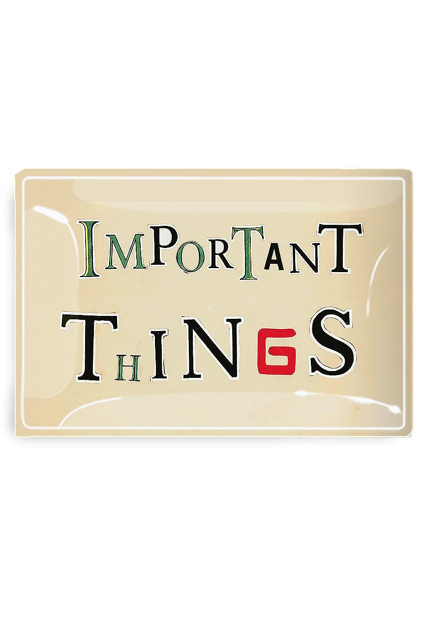 The Important Things Glass Tray by Faire is a rectangular handcrafted découpaged piece from New York, featuring black, green, and red vintage lettering with a bold red "G" in "THINGS.