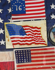 The Betsy Ross American Flag Glass Tray by Faire features vintage flag art with white stars, making it a striking piece of historical American decor perfect for display or découpage.