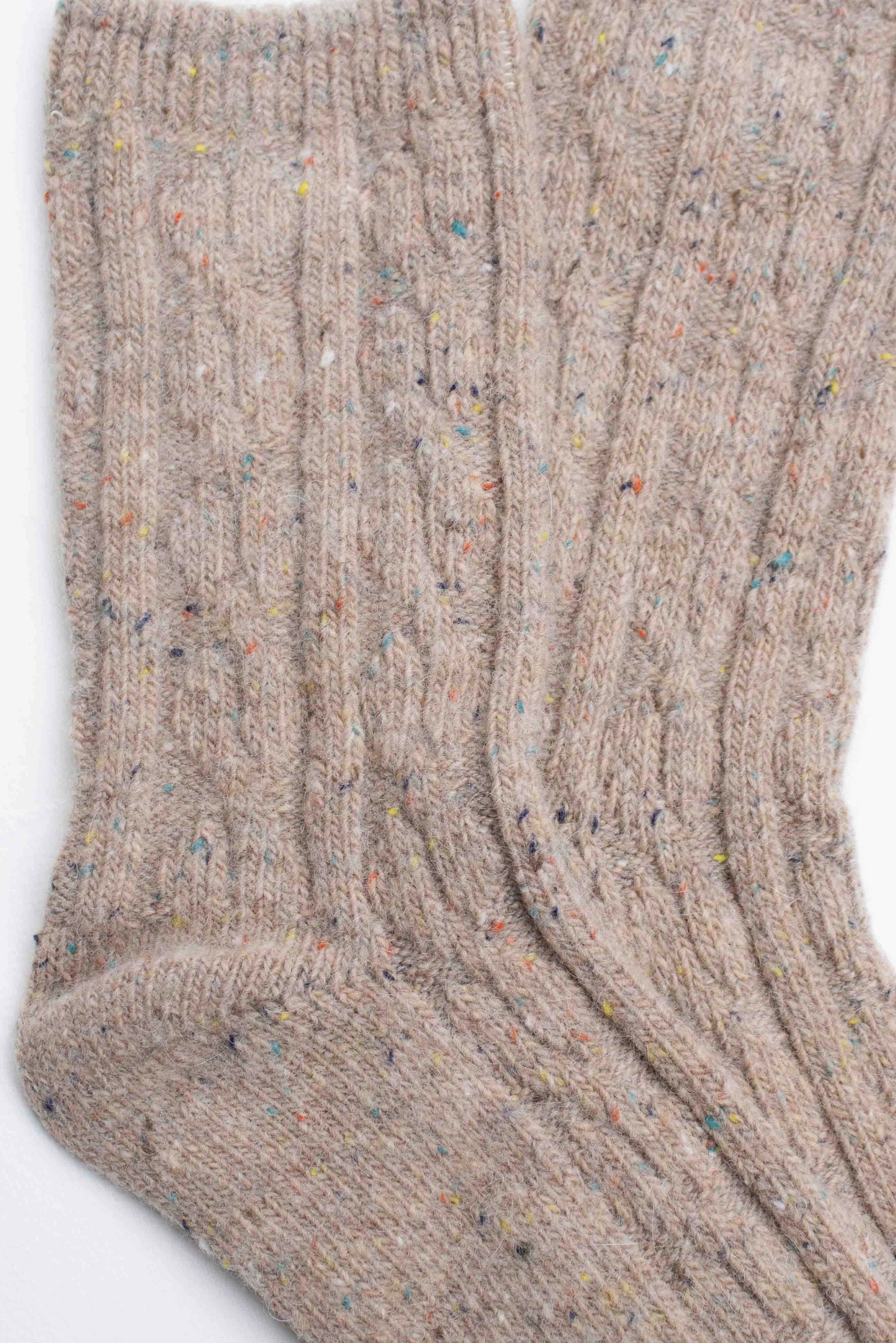 The Faire Wool Speckled Knit Socks are beige, cozy, and feature a ribbed cable-knit pattern with colorful specks in soft wool-blend fabric, shown laid flat on a white background.