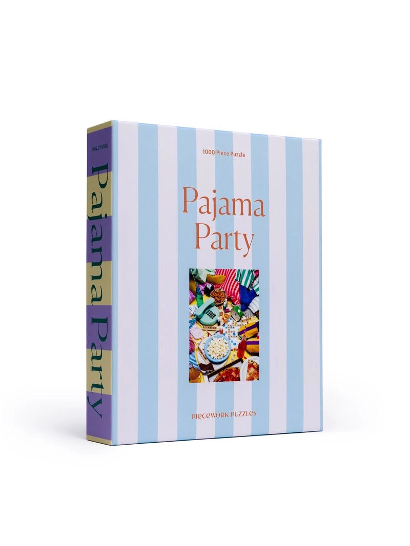 The Faire Pajama Party Puzzle is a 1000-piece jigsaw featuring colorful pajamas, snacks, and games on the box, accented by light blue and white vertical stripes. Made with recycled paper.