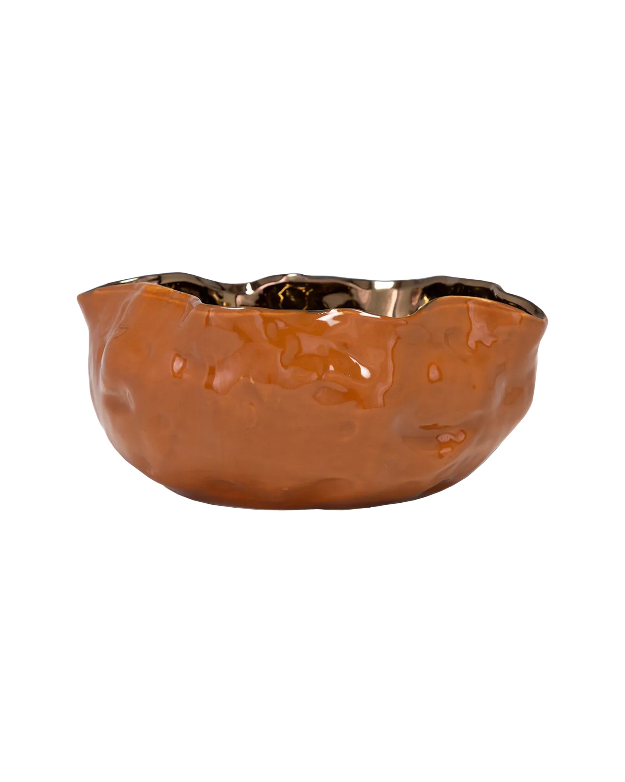 The Import Collection’s Abitar Bowl features a shiny, uneven metallic orange finish with a wavy rim and textured ceramic surface, making it a striking modern tabletop accent. Displayed on a white background.