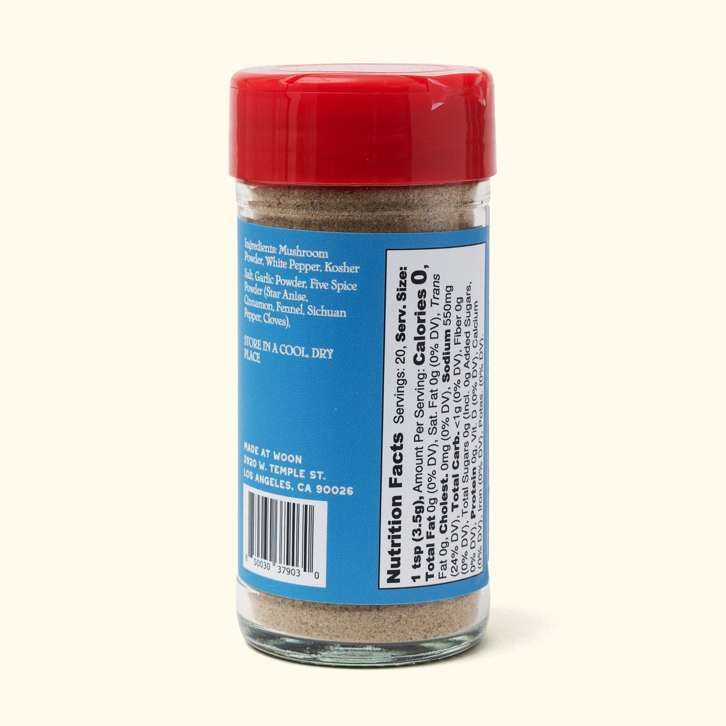 A glass spice jar with a red lid and blue label lists ingredients, storage tips, and nutrition facts. Inside is Faire’s Woon Wok Legend's Seasoning Salt—a fine beige blend perfect for adding bold flavor to your favorite dishes.