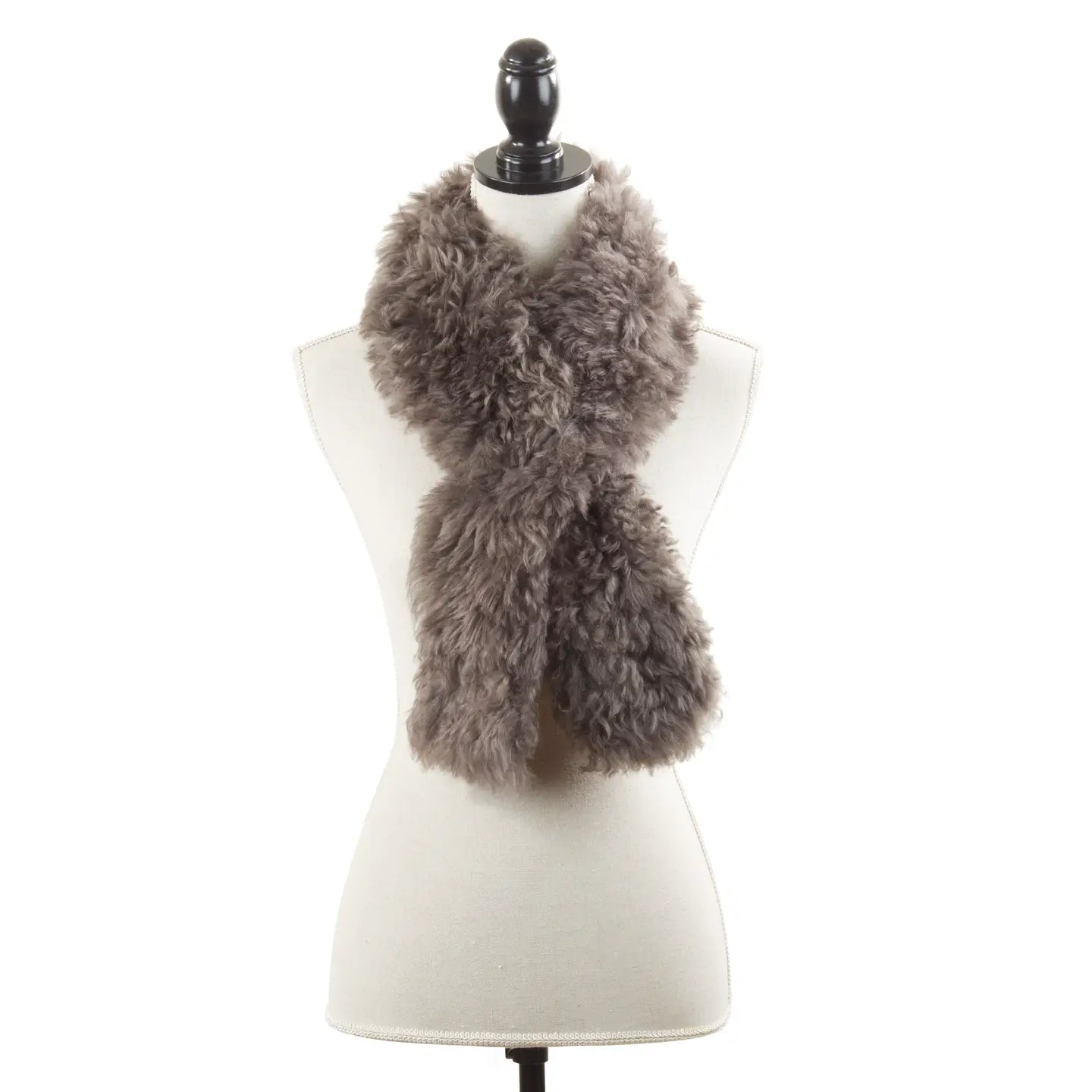 The Faire Lamb Fur Pull Through scarf, in light brown, is shown draped around a white dress form mannequin with a black finial, set against a plain white background to highlight its luxurious warmth and style.