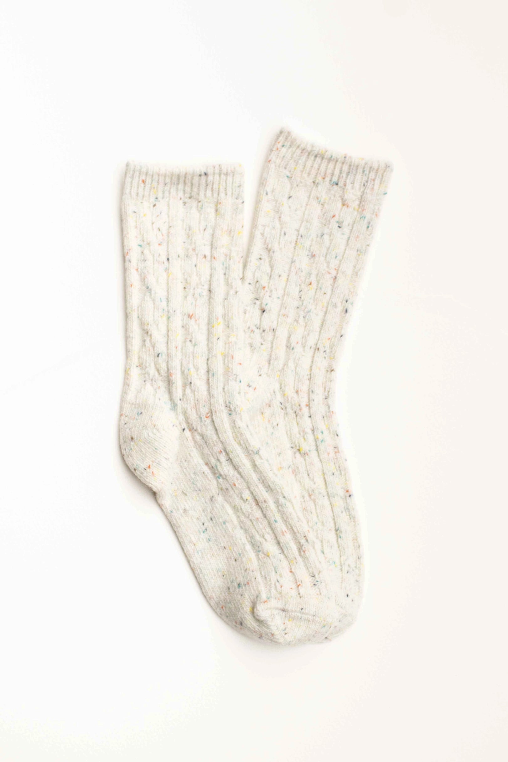The Faire Wool Speckled Knit Socks are white, wool-blend crew socks featuring subtle multicolored specks and a ribbed texture, shown laid flat on a white background.