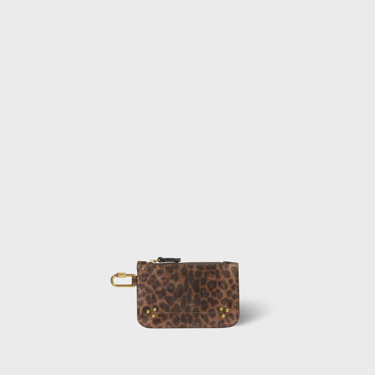 The Popoche XS Pouche by Jerome Dreyfuss is a small goatskin pouch in leopard print, featuring a top zipper, a gold carabiner clip on the side, and a convenient key fob. It also has four gold rivets on the front corners against a plain white background.