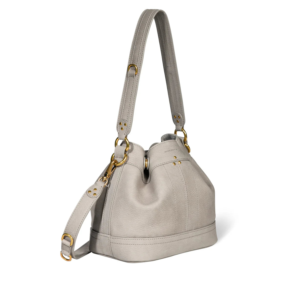 The Ben Small Bucket by Jerome Dreyfuss is a light gray calfskin handbag with gold hardware, featuring a structured shape, leather shoulder strap, and front flap for easy wearing. Its design is simple and elegant.