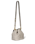 The Ben Small Bucket by Jerome Dreyfuss is a luxurious calfskin bucket bag in light gray, featuring a long leather shoulder strap, gold hardware, and a drawstring closure with a simple, elegant design.