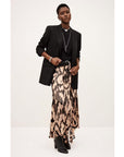 A person models the BA&SH Skirt Aley, paired with a black blazer, black top, boots, and silver jewelry, posing confidently against a plain light background.