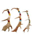 The Wool & Copper Wrap Deer Antler Fallow by Faire features three handmade antler pieces, each wrapped with vibrant yarn bands in red, orange, yellow, pink, blue, and green on a white background.