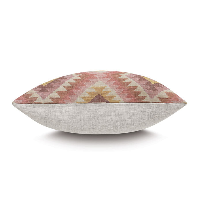 The REINHART KILIM pillow by Eastern Accents features a geometric chevron design in soft pink, peach, and yellow on top with plain beige fabric underneath. Shown from the side; pillow insert included.