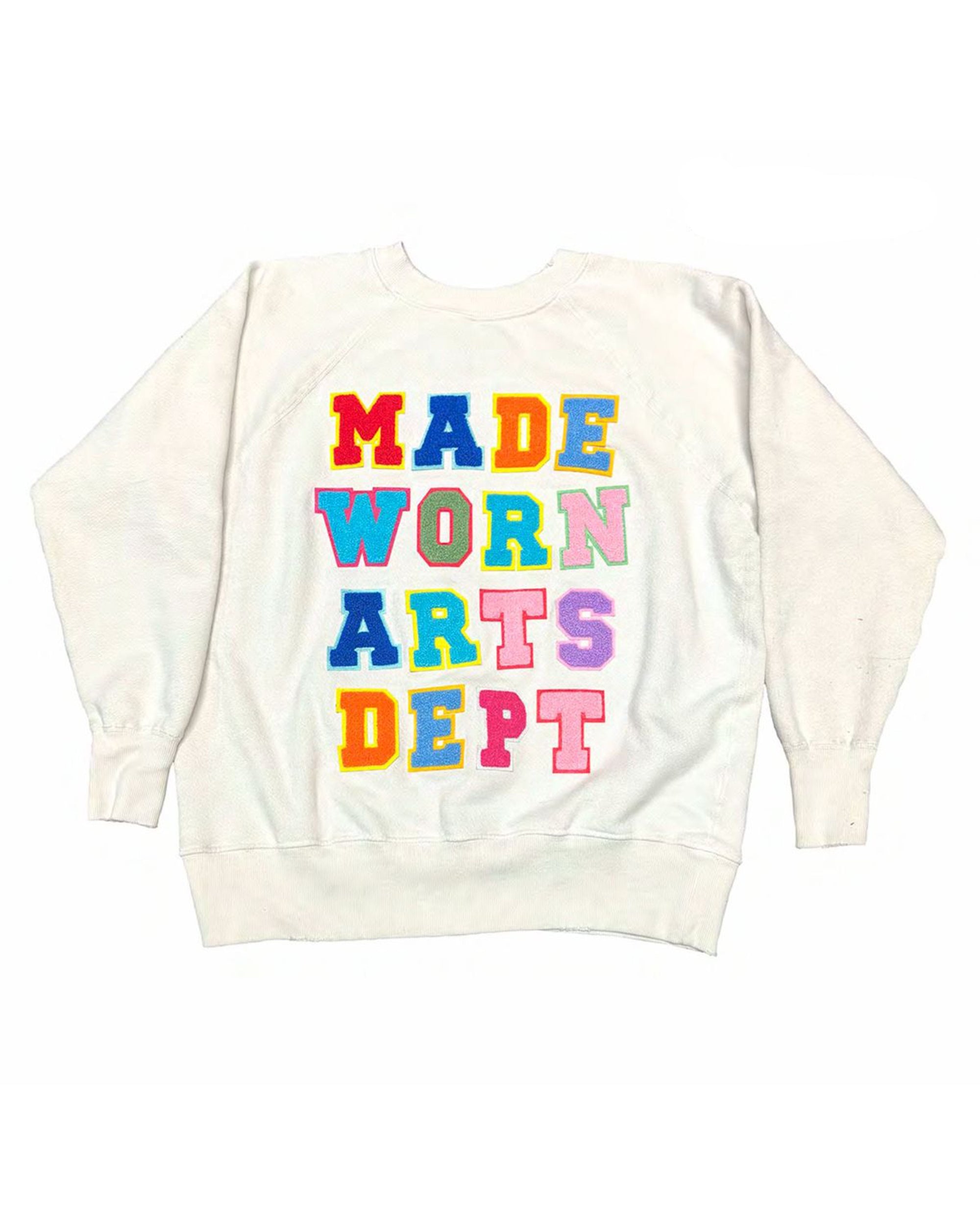 The Arts Dept Shrunken Sweatshirt Vintage White by Made Worn features "ARTS DEPT." on the back in bold, colorful varsity-style letters, each in a different vibrant shade for an eye-catching look.