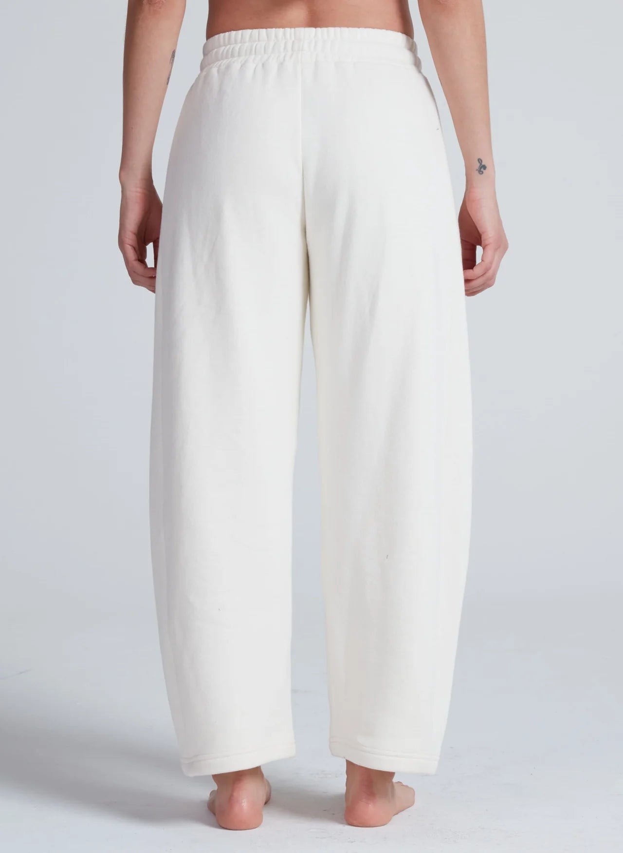 White high-waisted ASKK Cancun sweatpants in 100 cotton, barrel fit with elastic waist, shown from the back.