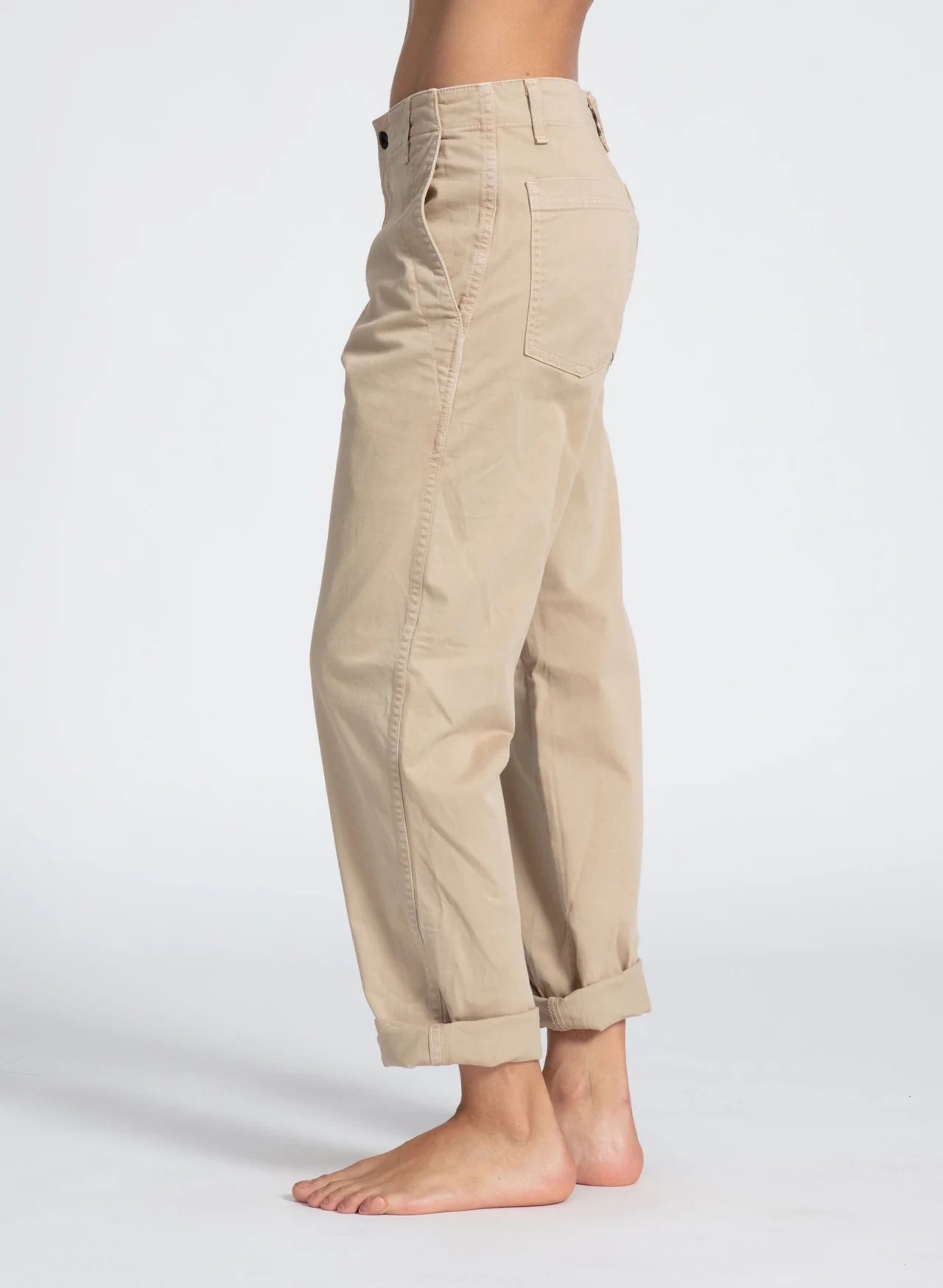 A person wearing ASKK Slim Chino pants in tan.
