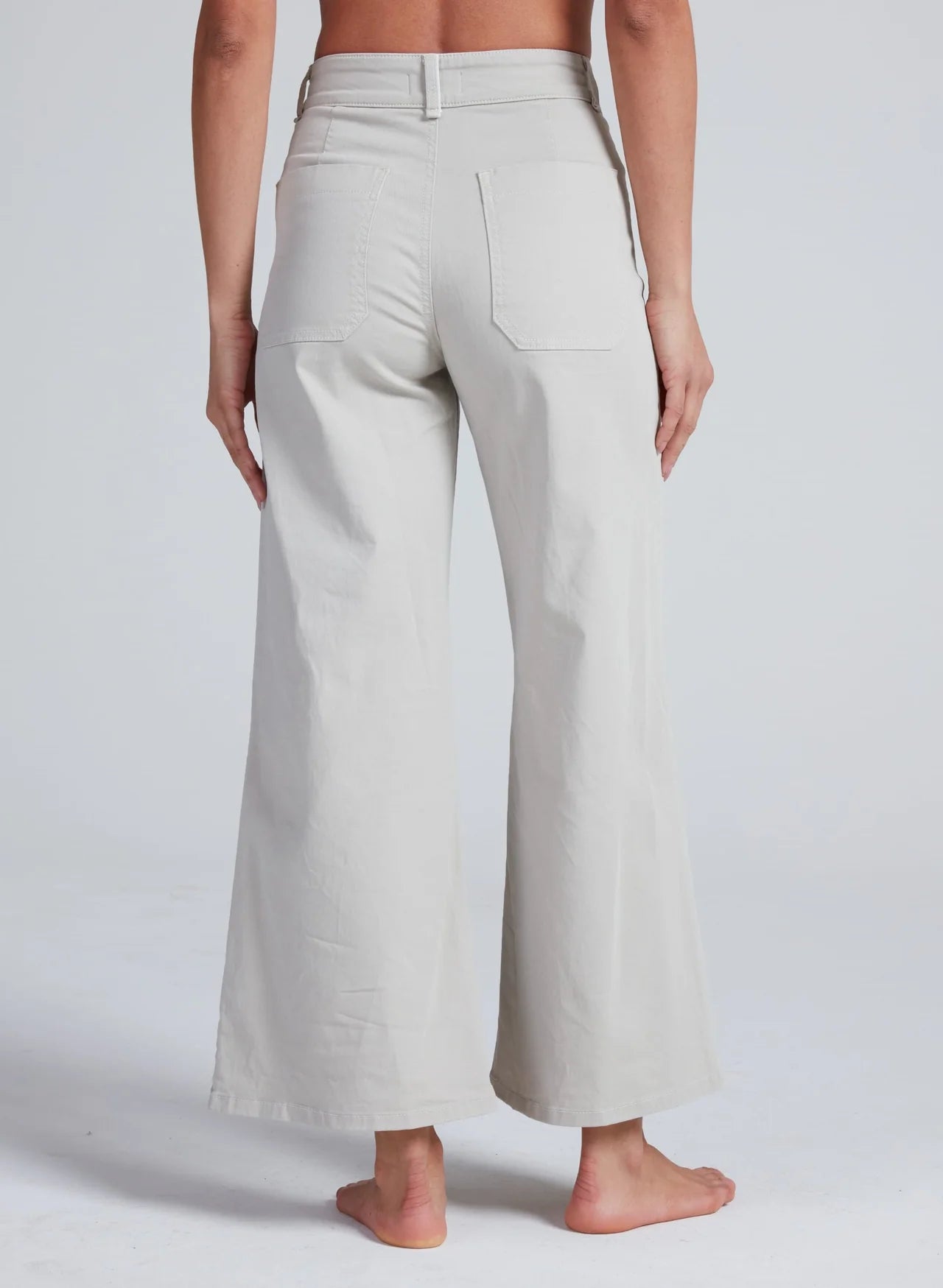 ASKK Cropped Sailor stretch twill wide-leg pants in navy, viewed from the back, barefoot model.