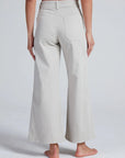 ASKK Cropped Sailor stretch twill wide-leg pants in navy, viewed from the back, barefoot model.