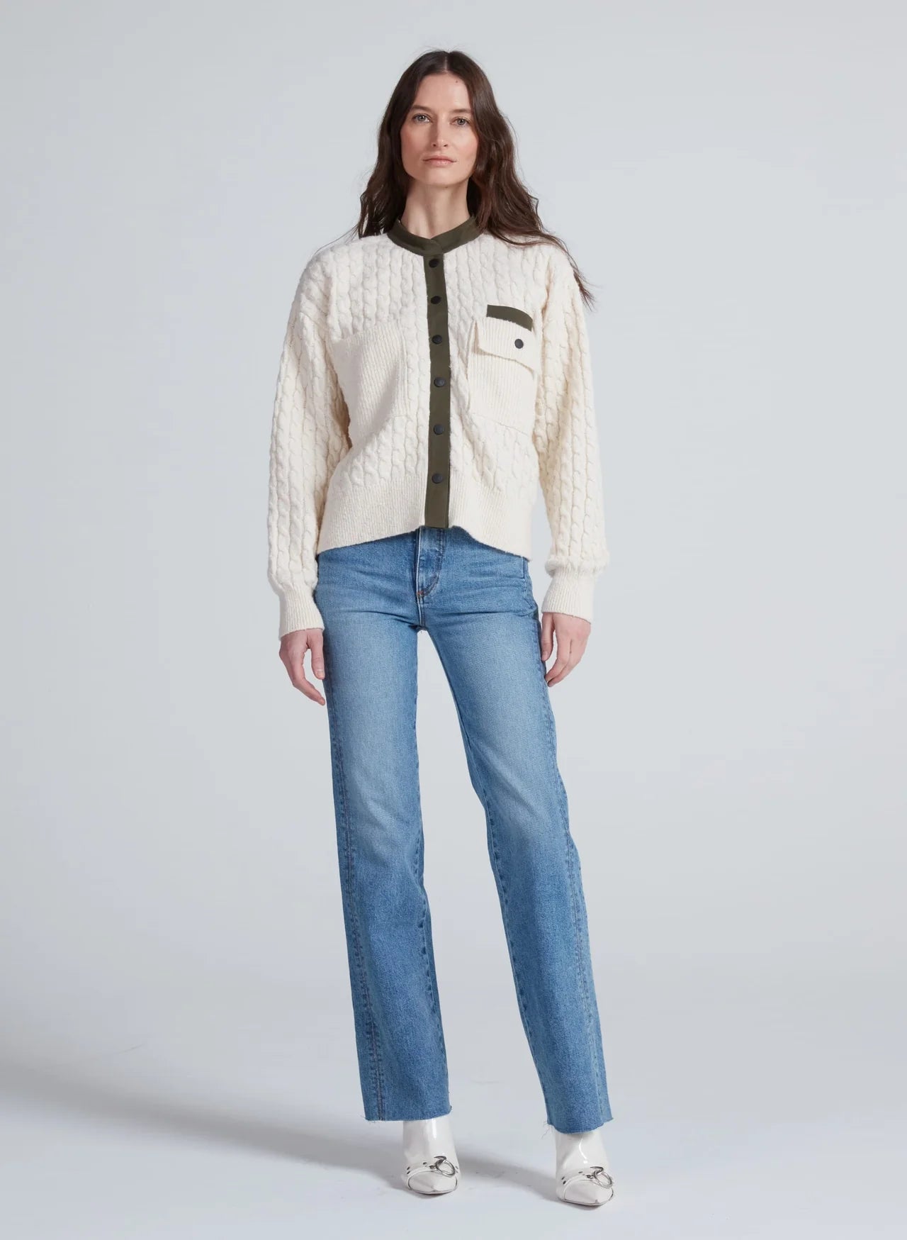 ASKK Greenwich Cardigan with green trim styled with blue jeans and white shoes, modern casual look.