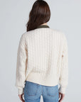 Cream knit Greenwich Cardigan by ASKK, seen from the back, styled with blue jeans for a relaxed look.