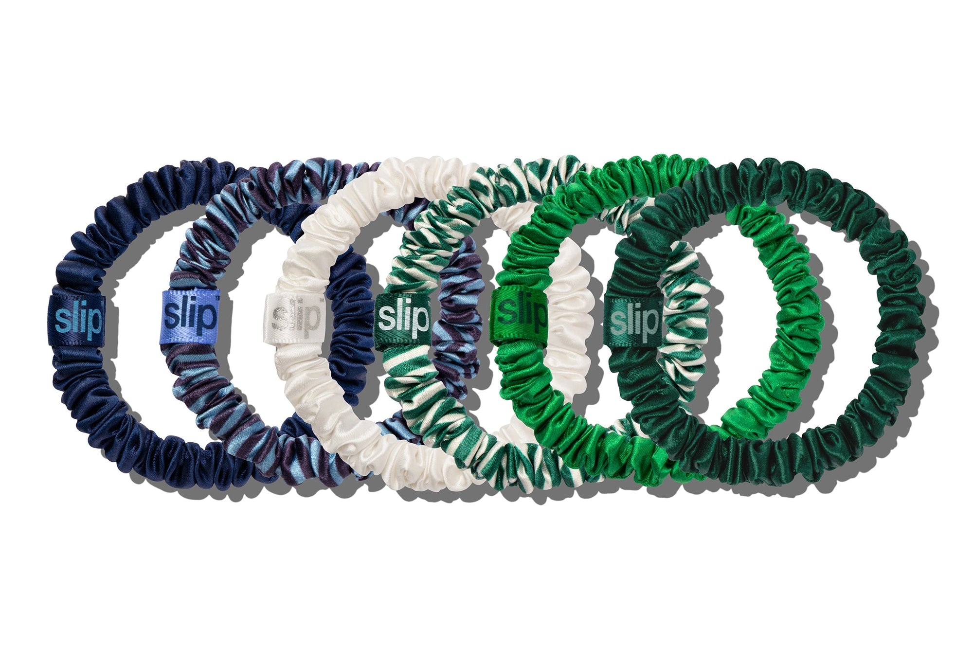 Six Faire Hair On Point Skinny Scrunchies w/ Pouch in navy, white, blue/white pattern, green/white pattern, and dark green protect against breakage and add style—each arranged in a row and featuring a branded tag.