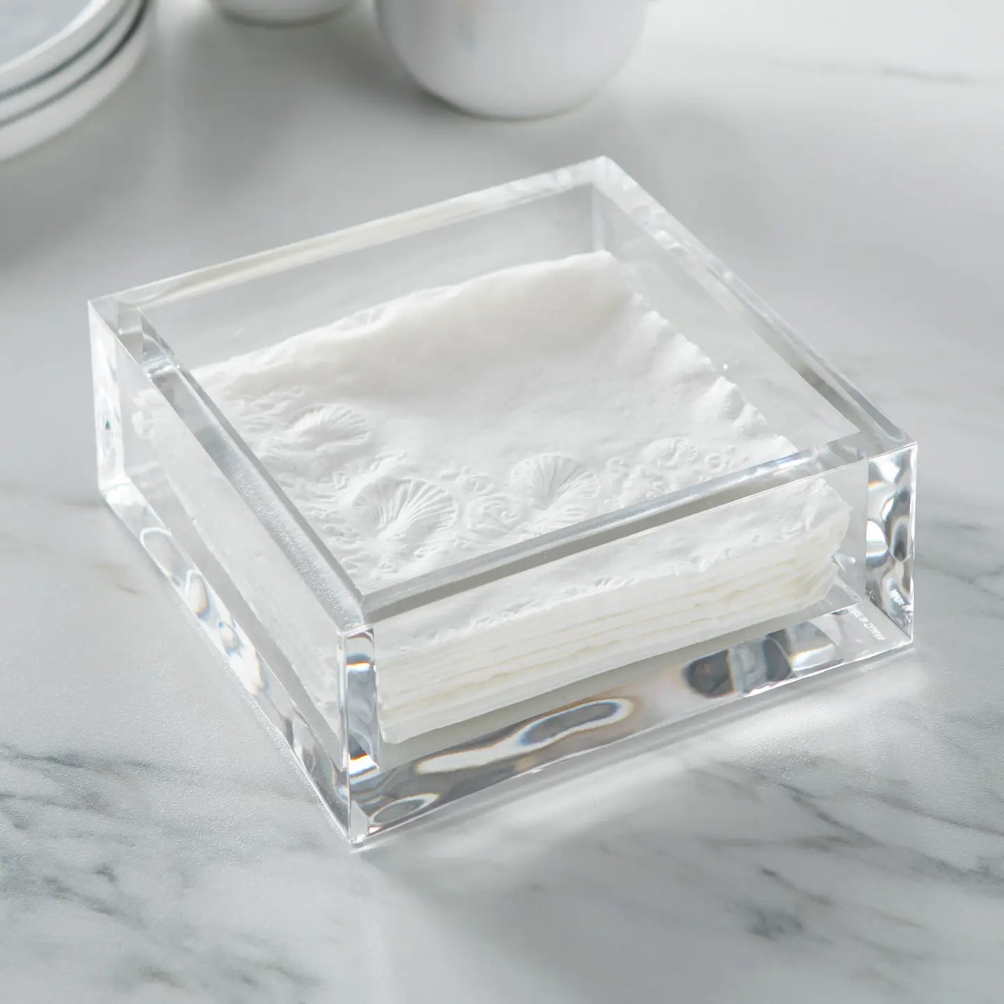 The Faire Cocktail Deluxe Napkin Holder showcases neatly stacked embossed white napkins, adding an elegant touch to your table setting.